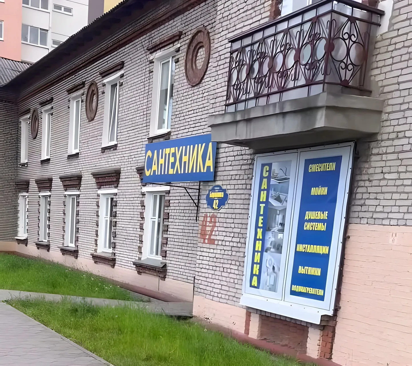 Магазин на Баранова, 42: синяя вывеска «САНТЕХНИКА» на кирпичной пятиэтажке